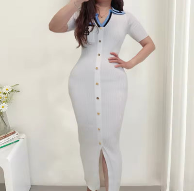 Robe moulante blanche, boutons dorés et col contrasté bleu et noir, style féminin et moderne.